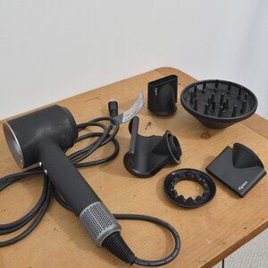 black dyson hair dryer with all the accesories